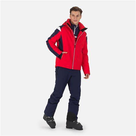 Modello di uomo che indossa una giacca da sci O'Neill rossa in montagna, sorridendo.