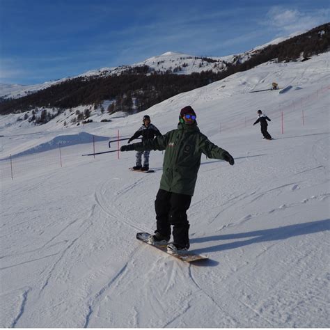 Maestri di snowboard che guidano un gruppo di allievi su una pista innevata a Livigno