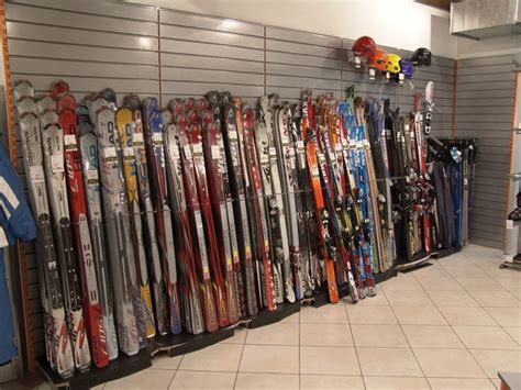 Vetrina di un negozio di articoli sportivi con sci e snowboard esposti.