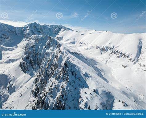 Panorama alpino con montagne innevate e cielo azzurro