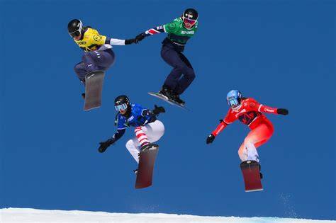 Atleti di snowboard impegnati in una gara di snowboard cross, con dossi e curve strette.