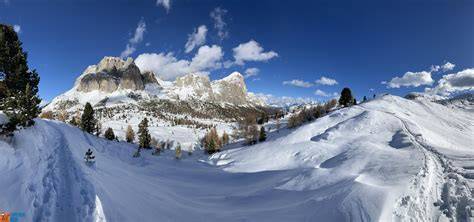 panoramica delle Dolomiti con neve fresca e larici dorati