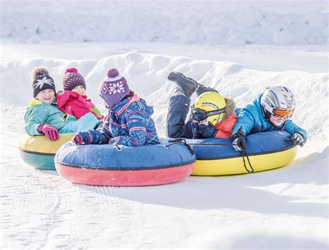 Persone che fanno snow tubing su una pista innevata in montagna