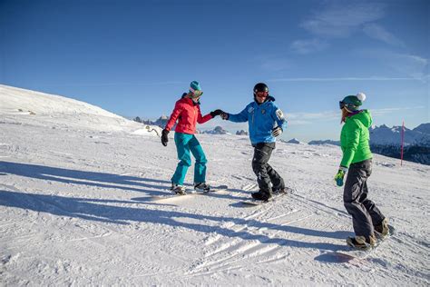 Maestro di snowboard con allievi su una pista innevata.