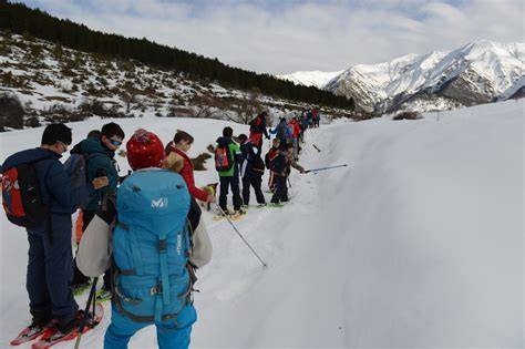 Gruppo di escursionisti con ciaspole su un sentiero innevato