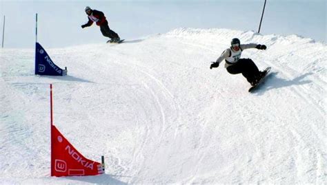 Atleti di snowboard in azione durante una gara di gigante su una pista innevata