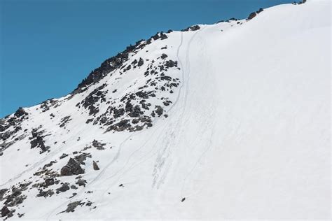 Immagine di un ripido canale innevato con rocce circostanti