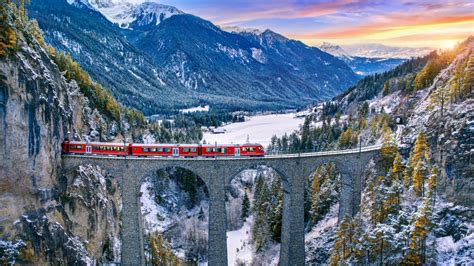 Treno panoramico che attraversa un paesaggio alpino innevato