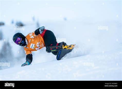 Snowboarder in azione durante una gara di gigante parallelo in notturna