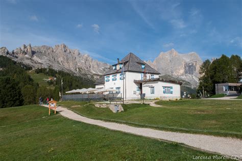 Alpinista con abbigliamento casual davanti a un rifugio alpino