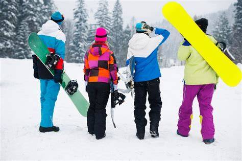 Giocatori di snowboard che si divertono sulla neve fresca