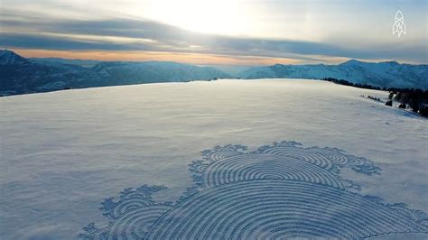 Simon Beck che cammina sulla neve, lasciando tracce che formano un disegno geometrico