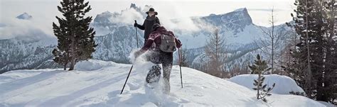 Donna che utilizza le ciaspole in un paesaggio innevato