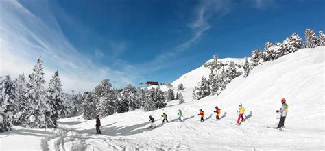 Panoramica di una piccola località sciistica con piste per bambini e tapis roulant.