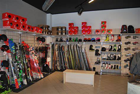 Vetrina di un negozio di articoli sportivi invernali con sci, snowboard, caschi e abbigliamento tecnico