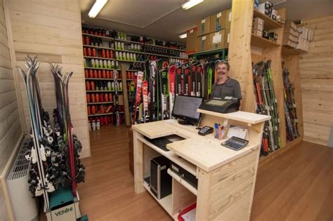 Immagine di un moderno negozio di noleggio sci con sci e snowboard allineati, rappresentante Marcellin Rent.