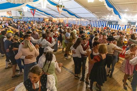Gente che balla e si diverte in un tendone da festa bavarese con musica dal vivo