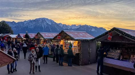 Mercatino di Natale con bancarelle illuminate e persone che passeggiano