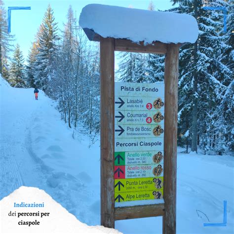 Sentiero con indicazioni per ciaspole e piste da sci, con baitella in pietra