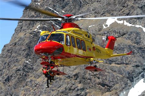 Immagine di un elicottero di soccorso alpino in volo in ambiente montano