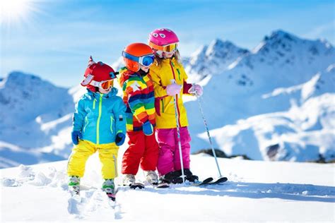 Bambini che giocano sulla neve con abbigliamento da sci colorato ZIENER
