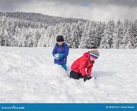 Panorama innevato delle Alpi Trentine con bambini che giocano nella neve.