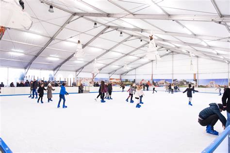 Vista dall'alto della pista di pattinaggio coperta del Rimini Ice Village, con il mercatino natalizio e il mare sullo sfondo