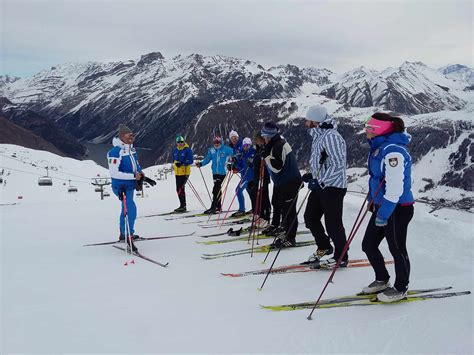 Maestri di sci di fondo con allievi su una pista panoramica