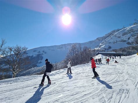 Sciatori che si divertono in un comprensorio sciistico con condizioni di neve miste (pista e un po' di fuoripista).
