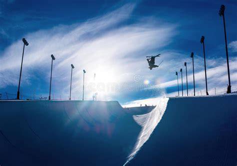 Sciatore freestyle che esegue un salto in uno snowpark.