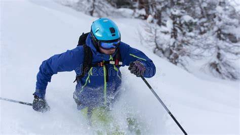 Sciatore freeride che scia su un pendio di neve fresca.