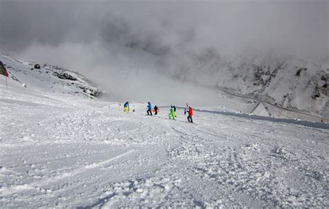 Sciatori che percorrono un tratto ampio e innevato della pista La Bellunese