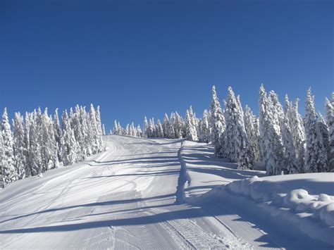 Panorama delle montagne innevate con una pista da sci preparata, tipica delle località di Coppa del Mondo.
