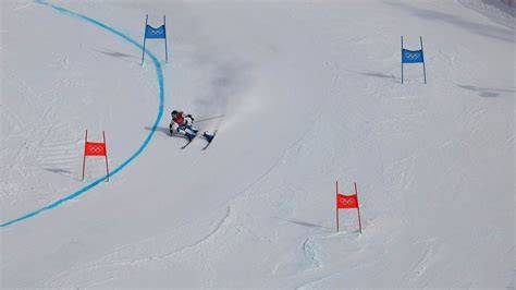 A skier making wide, sweeping turns on a giant slalom course.