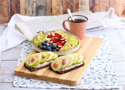 Immagine di una colazione dolce equilibrata con pane integrale, marmellata, frutta e yogurt.