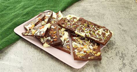 Immagine di uno snack da pista: frutta secca, cioccolato fondente e una bottiglia d'acqua.