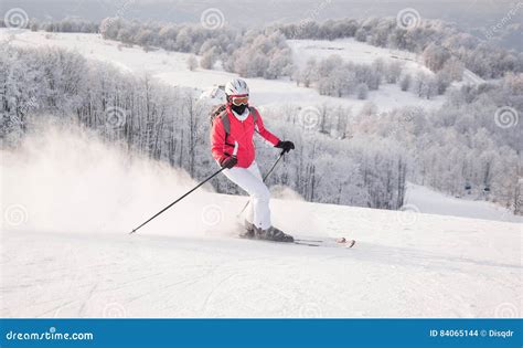 Sciatore in azione in discesa su neve fresca, con enfasi sulla posizione del corpo e sulla fluidità del movimento.