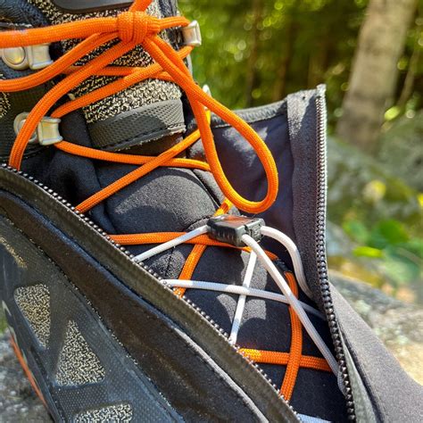Dettaglio del sistema di allacciatura autobloccante di uno scarpone da alpinismo, con particolare enfasi sui ganci di bloccaggio.